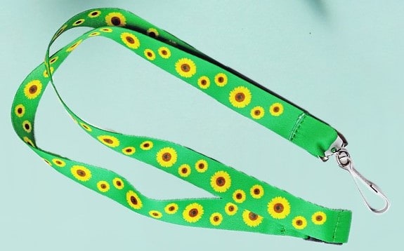 The hidden disabilities sunflower lanyard is green with yellow sunflowers dotting all over it.
