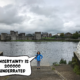Meggie with her blue jacket is standing proudly at a boat ramp leading down to the water of the River Shannon in downtown Limerick, Republic of Ireland. The sky is gloomy, dark, and full of clouds. Behind her and the river is the grey bricked King John's Castle. A comic text bubble from Meggie says, "Uncertainty is so overrated"
