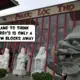 Statues of a lion and powerful human figures stand in front of a famous Vietnamese shopping building called Phuoc Loc Tho, with its red decor and lettering, in Asian Garden Mall, Bolsa Avenue, Westminster, Little Saigon, Orange County, California, United States of America. A comic text bubble says, "And to think Arby's is only a few blocks away"