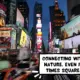 Times Square, Manhattan, New York City, New York State, United States of America. Lots of flashy lit-up billboards lining the street. Lots of tall buildings and skyscrapers. The cars are whizzing by. The scene is at night. A comic text bubble says, "Connecting with nature... even in Times Square!"
