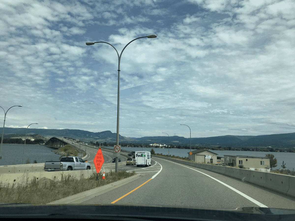 Canadian Highway 97/Okanagan Highway's William R Bennett Bridge over the Okanagan Lake between West Kelowna and Kelowna, British Columbia, Canada. The sky has lots of little clouds.