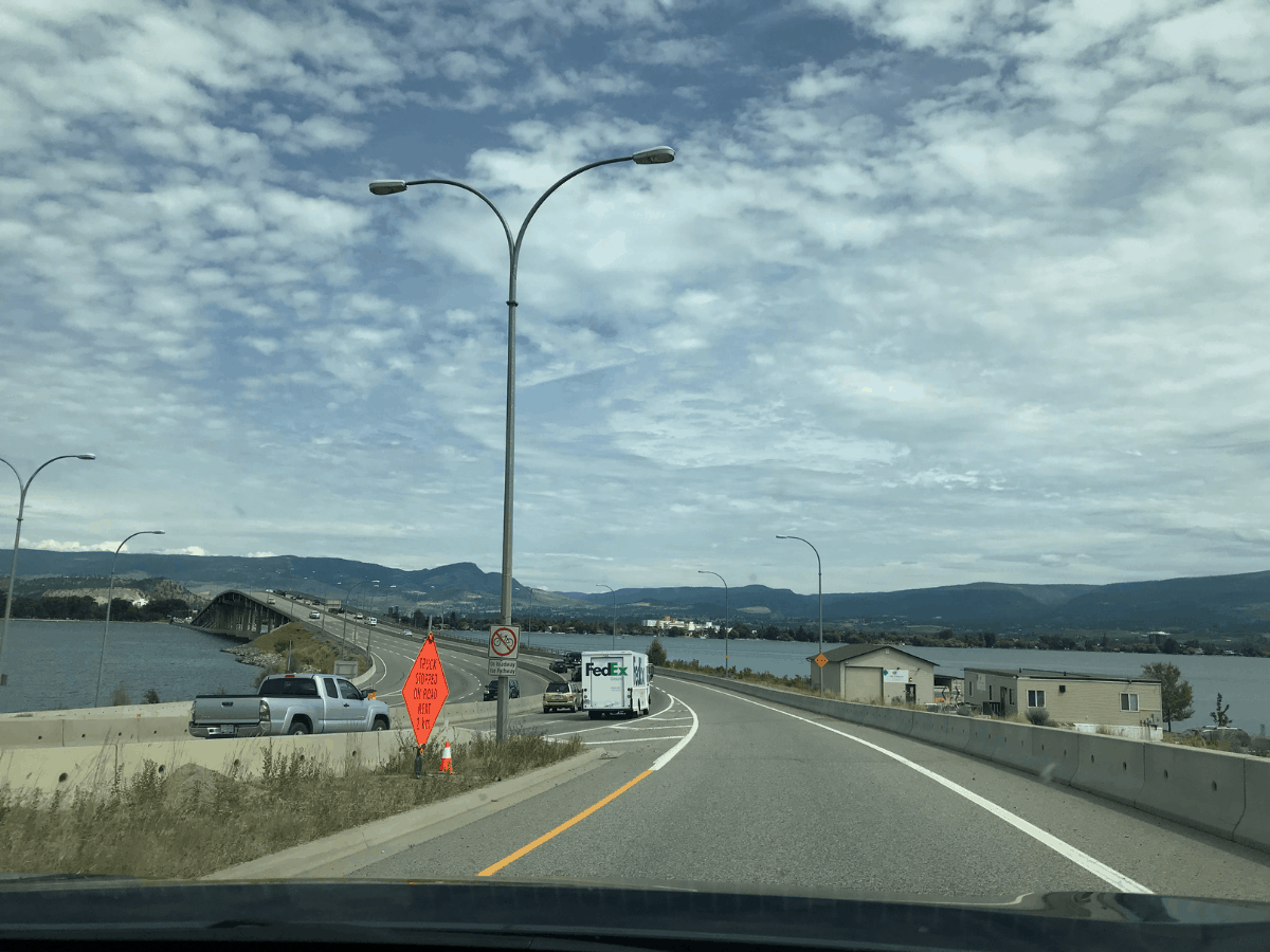  autostrada Canadiană 97/Podul William R Bennett al autostrăzii Okanagan peste Lacul Okanagan între West Kelowna și Kelowna, British Columbia, Canada. Cerul are o mulțime de nori mici.