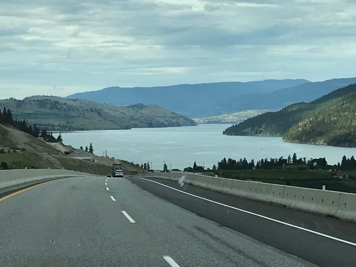 Canadian Highway 97/Okanagan highway che attraversa la valle di Okanagan a Kelowna, Columbia Britannica, Canada. La strada sta scendendo giù per una collina verso la distesa del lago Okanagan.