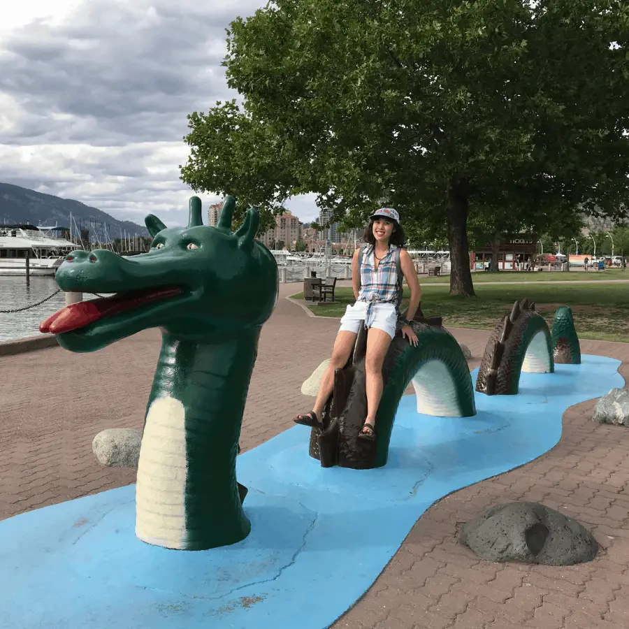 In real life Kelowna, British Columbia, Canada, Meggie is painfully sitting on the back of the Ogopogo concrete statue along the shores of the Okanagan Lake and the Downtown Marina dock.