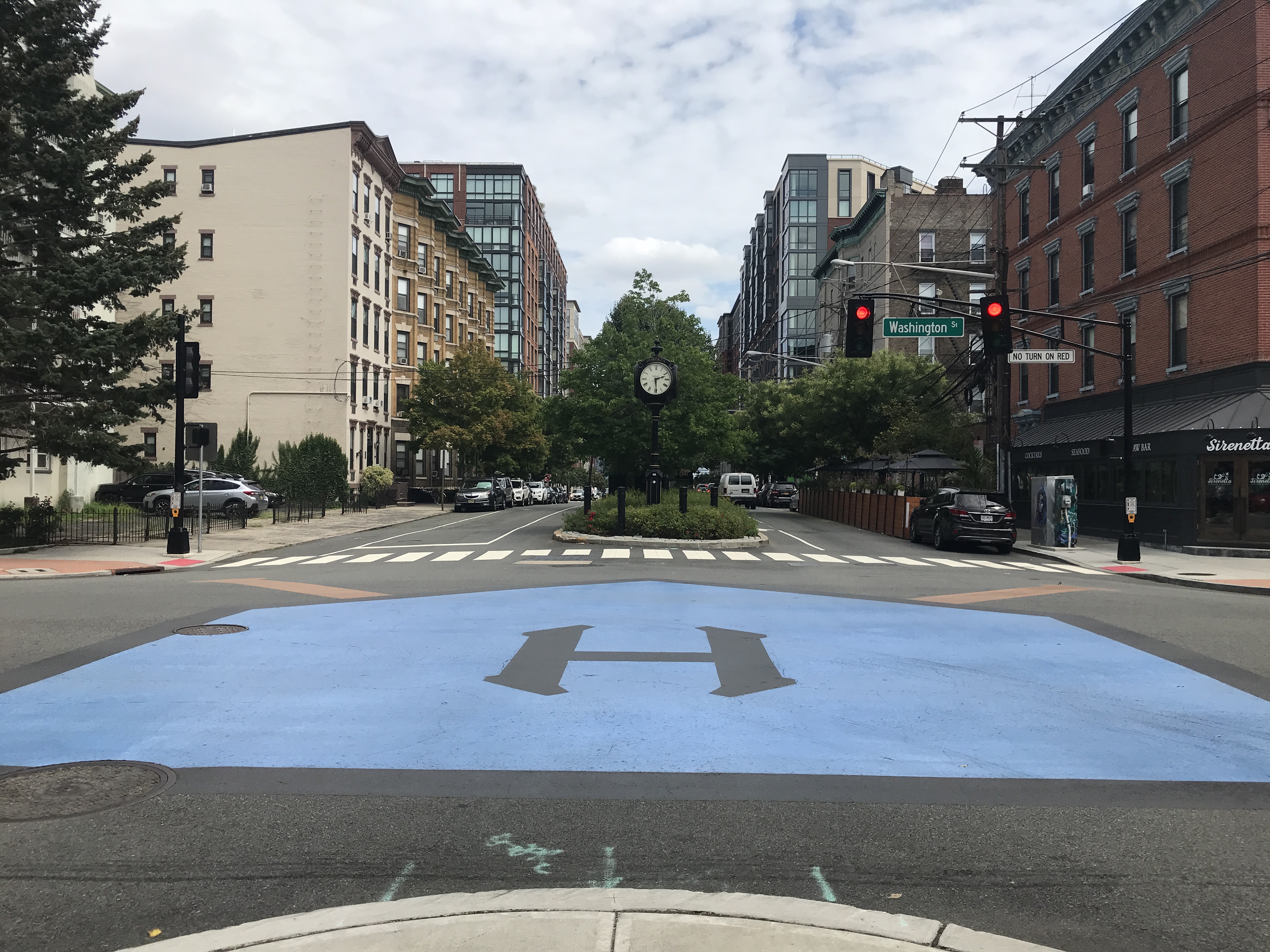 The intersection of Washington Street and 11th Street in Hoboken is painted with a blue baseball field to show where baseball was born. Sky is mostly cloudy. Hoboken, New Jersey, United States