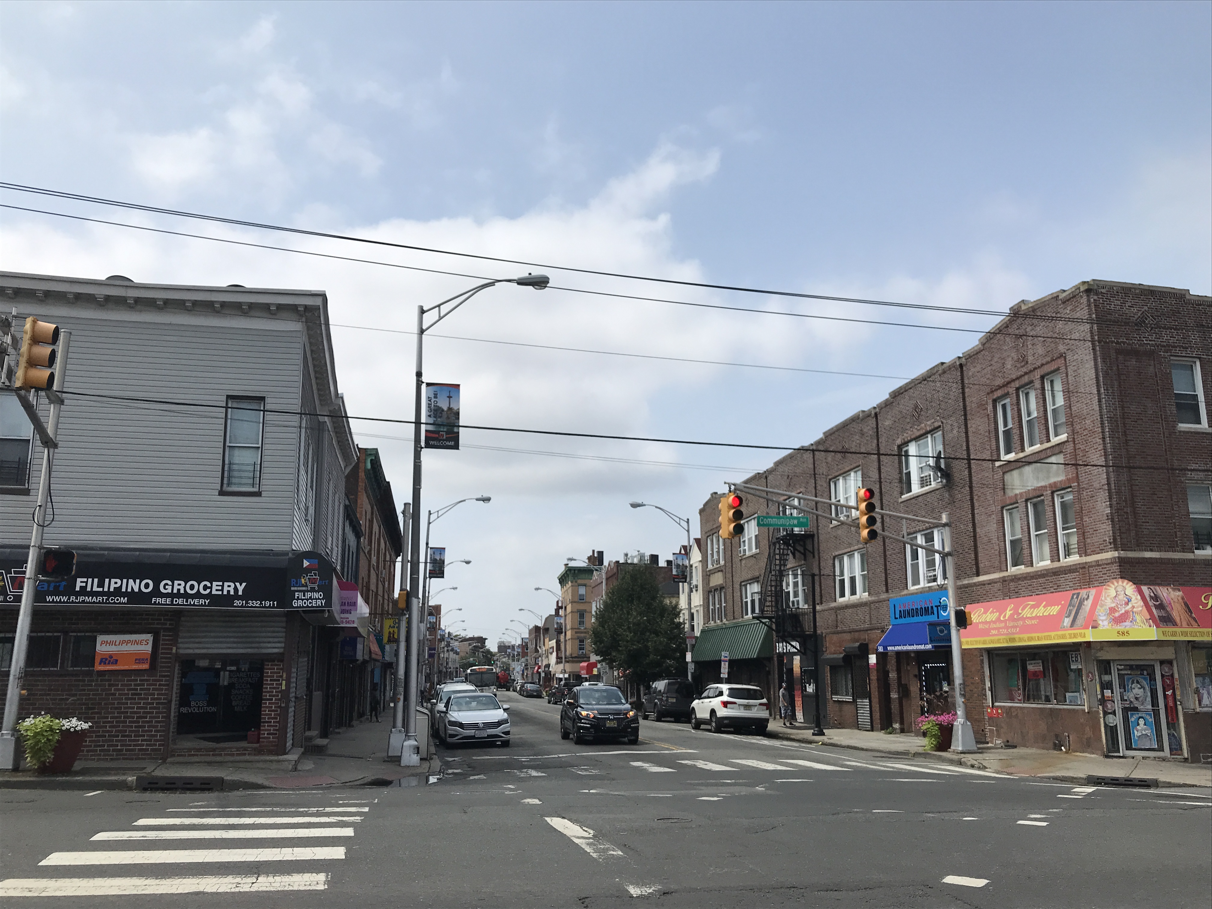 West Side Avenue includes a Filipino grocer. Partly cloudy blue sky. Jersey City, New Jersey, United States