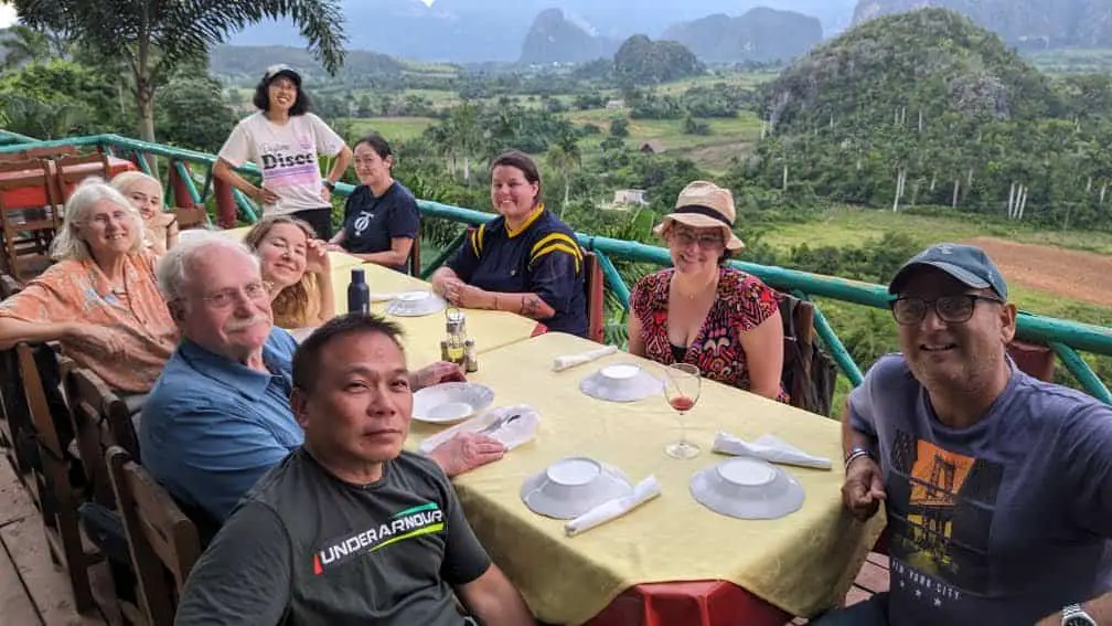 Meggie and the tour group and leader sitting at a restaurant overlooking the green hills of Viñales, Cuba,