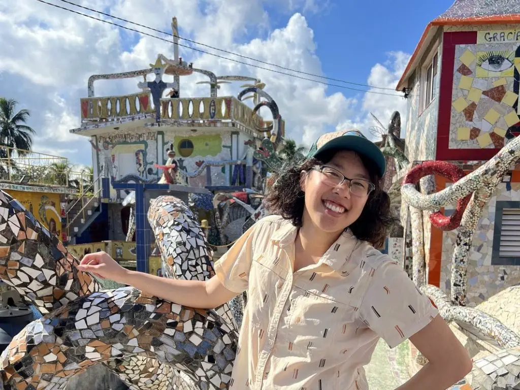 Meggie in a tan shirt standing in front of mosaics in Fusterlandia, Havana, Cuba.