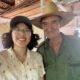 Meggie in a white shirt is taking a selfie with a Cuban farmer wearing a wide-brimmed hat and green clothes.