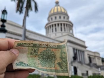 A 5 Cuban peso bill that Meggie's tour leader, Will, is holding in front of the National Capitol Building in Havana