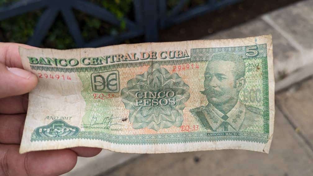 A green Cuban peso bill held by Meggie's tour guide while walking the sidewalks of Cuba