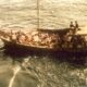 My dad's wooden boat on the sea. A pile of nearly faint people are lying at the bow.