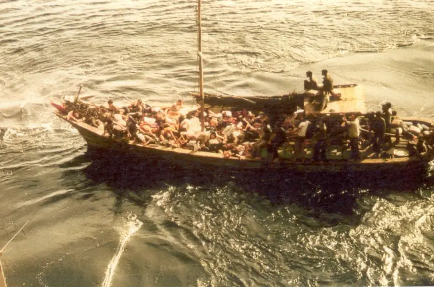 My dad's wooden boat on the sea. A pile of nearly faint people are lying at the bow.