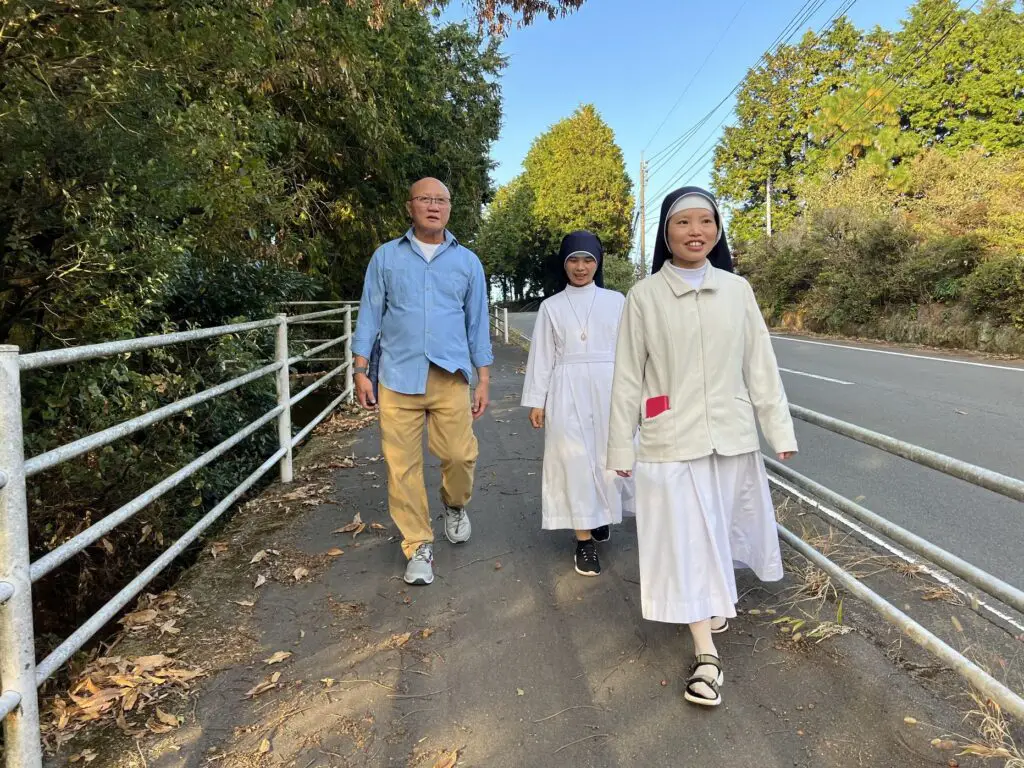 Sisters Nga and Huệ leading my dad down the rural streets by the convent.